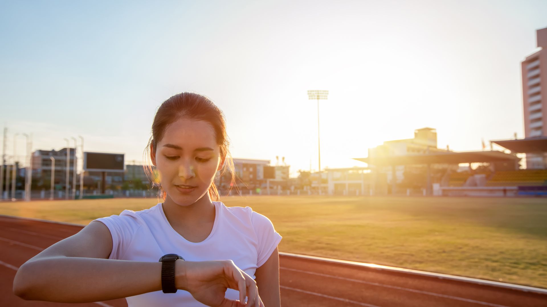 Woman with a smartwatch running in the sun