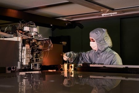 An engineer working with a display mask writer